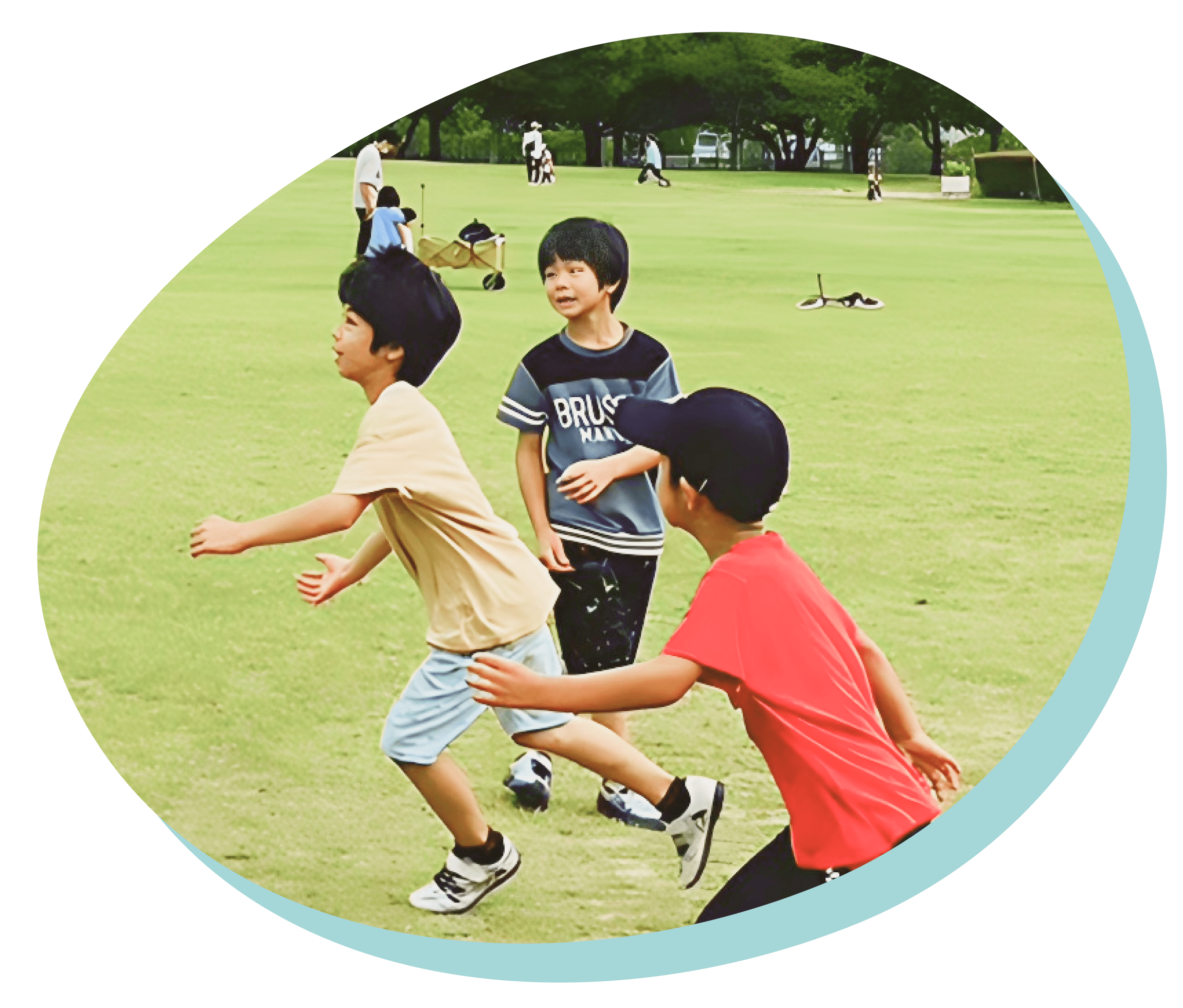 芝生のグラウンドでラグビーで遊ぶ子どもたちの様子