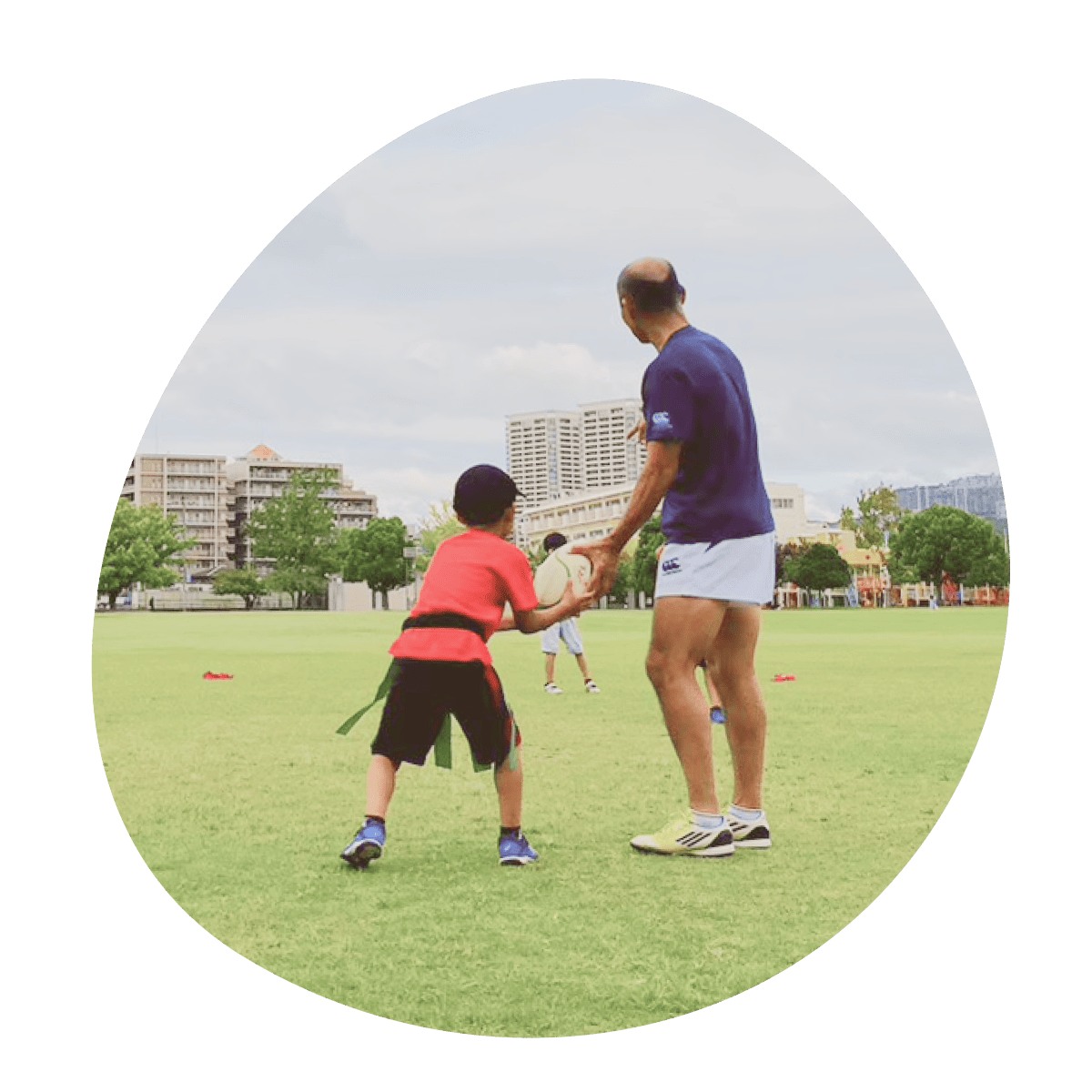 ボールパスをもらう男の子と西田コーチの後ろ姿